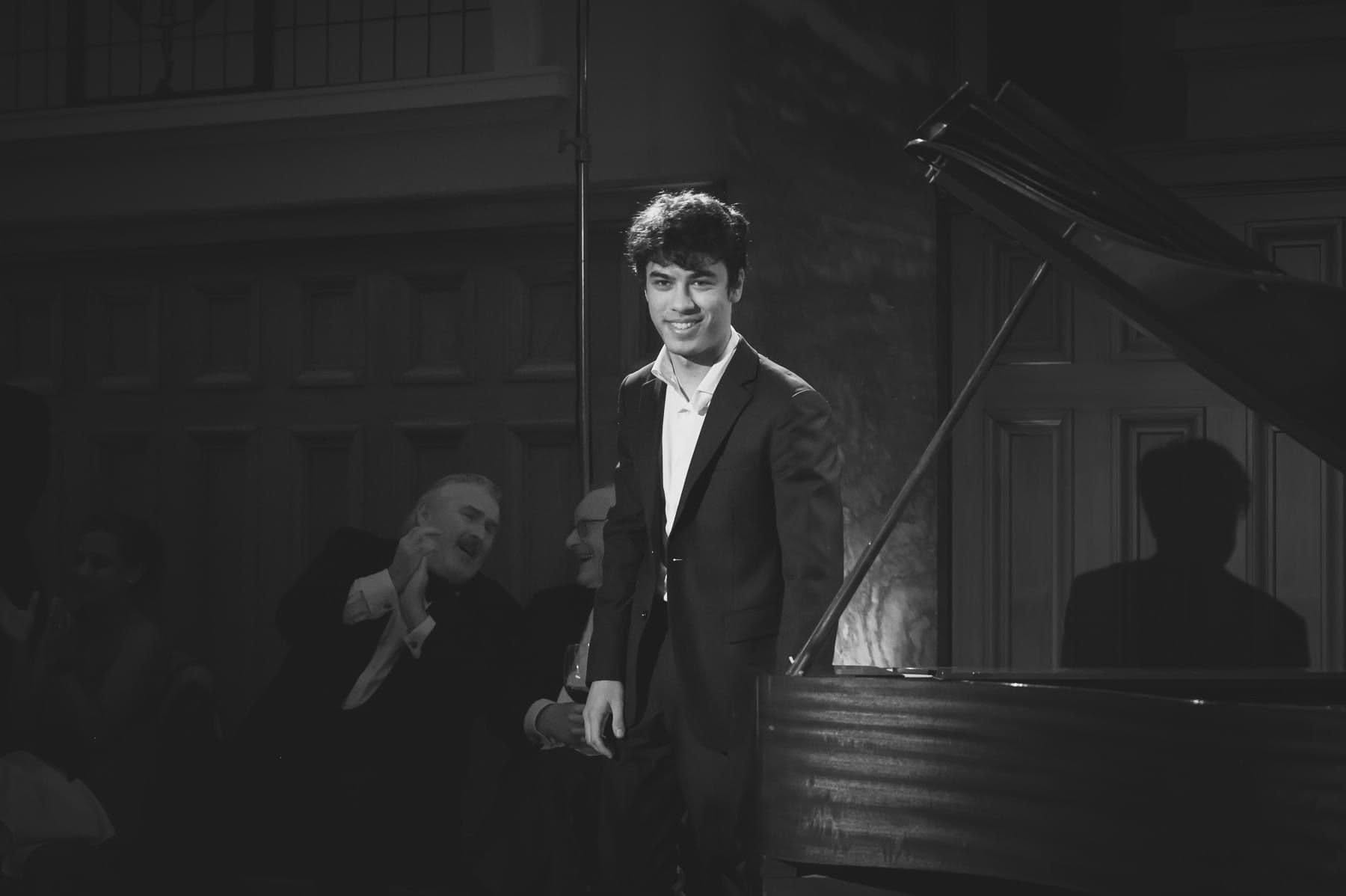 Benjamin Carter standing beside a grand piano after a performance